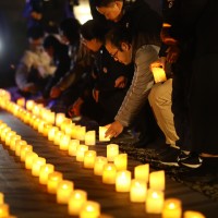 People put down candles at Nanjing Massacre memorial