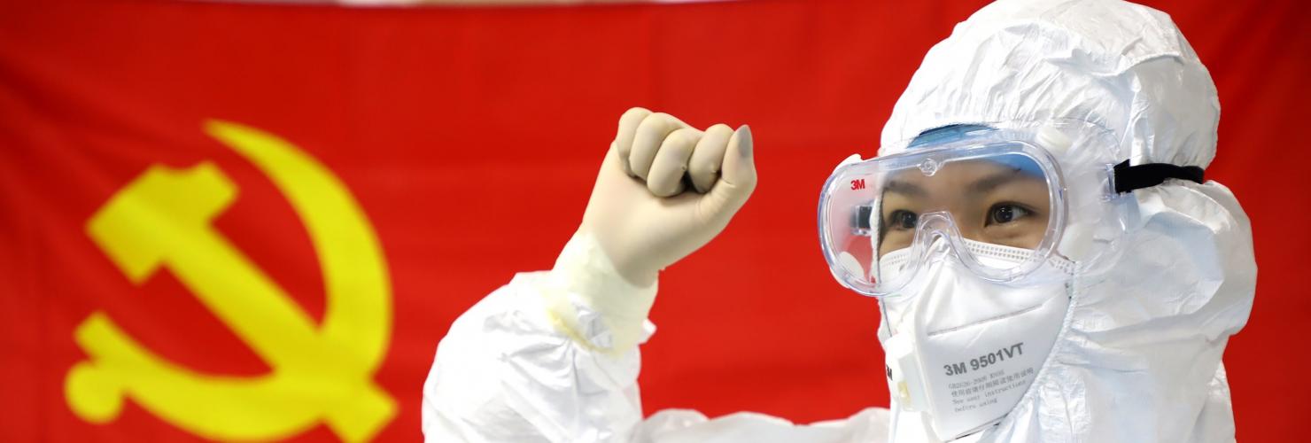 Chinese medical worker in front of a flag of the CCP