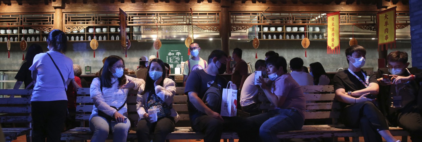 People, most with masks, enjoy visiting an event featuring old streets and atmosphere in Beijing, China.