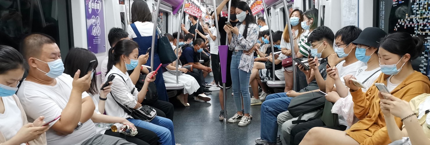 People on their phones in a Beijing subway