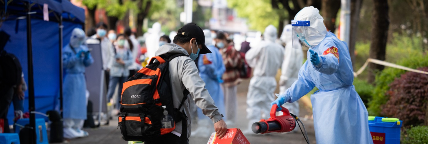 A staff member helps a villager disinfect baggage when he returns to Lianqin Village