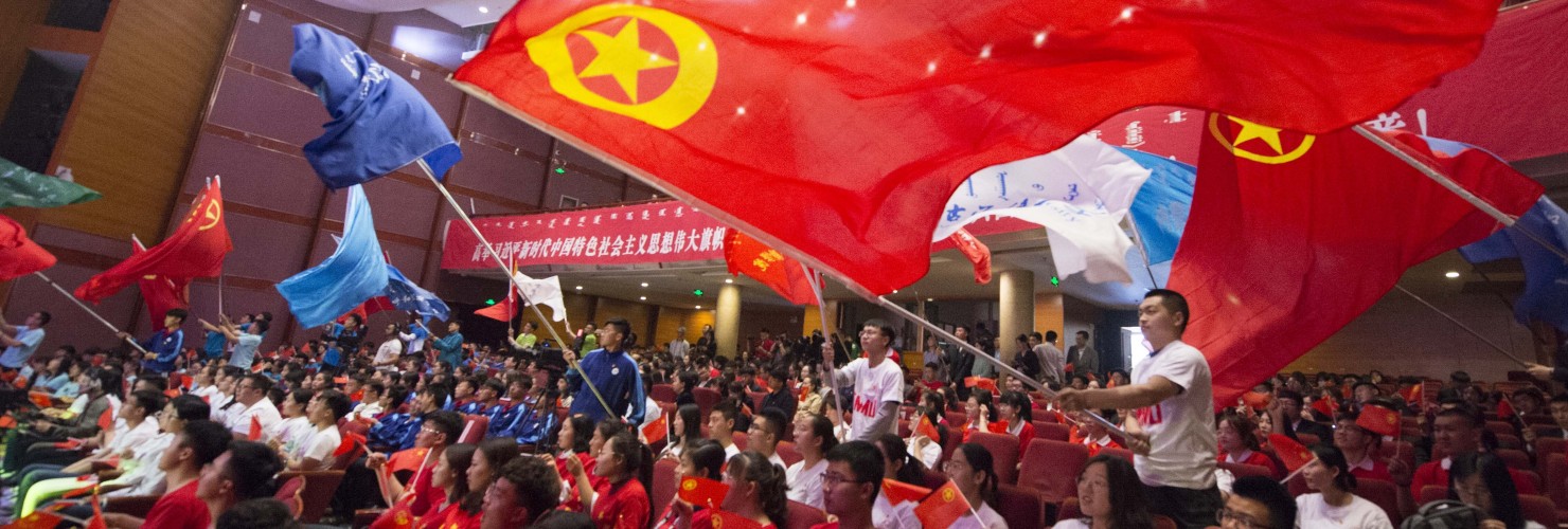 Young Chinese students from local universities wave flags of China and the Communist Youth League of China during a theme event to celebrate the upcoming 100th anniversary of the May Fourth Movement in Hohhot