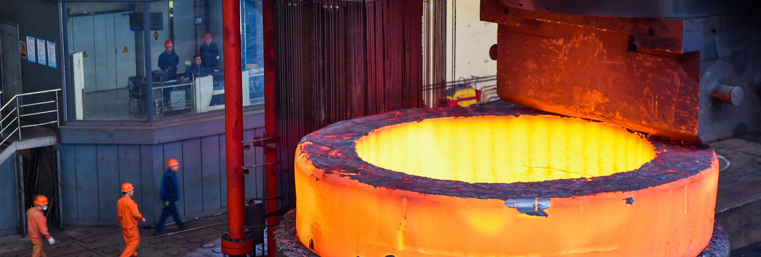 Chinese workers check a seamless forging piece at a forging workshop of CITIC Heavy Industries Company in Luoyang city, central China's Henan province