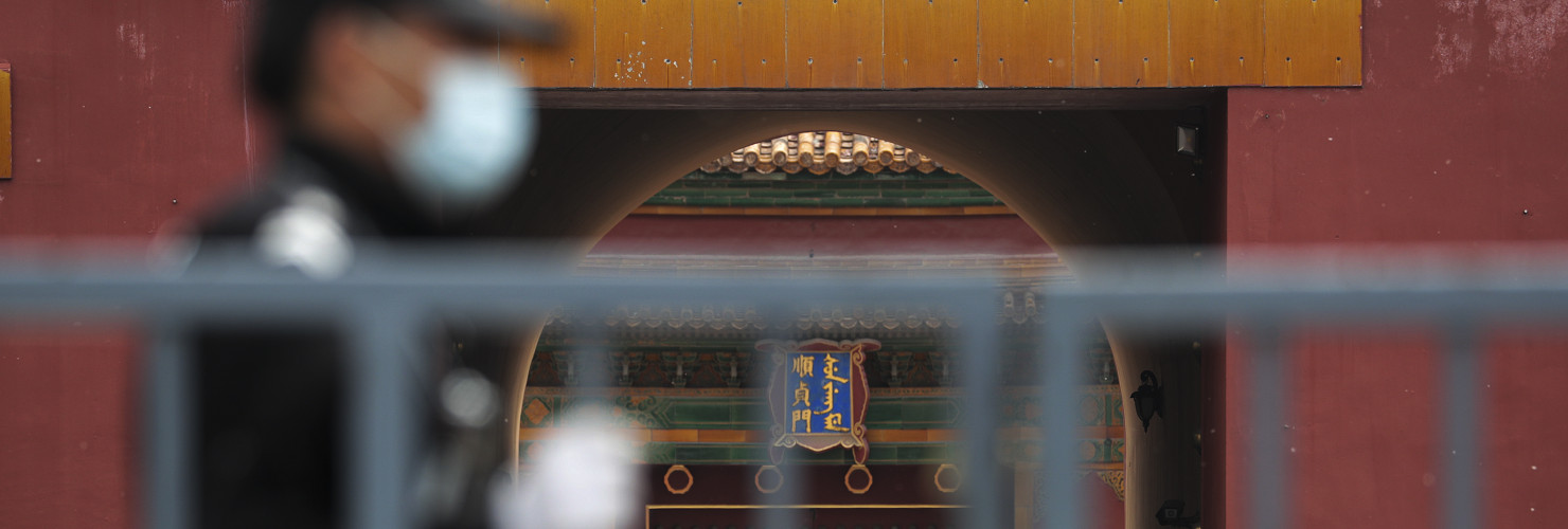 Security guards stand guard at the closed gates of the Forbidden City