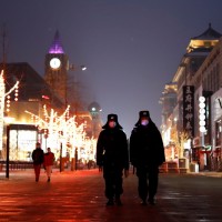 Security guards walking down Wangfujing street in Beijing.