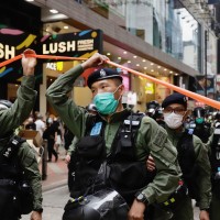 Policeman pass through a cordon line in the city centre on the PRC national day in Hong Kong.