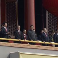 Chinese President Xi Jinping, center, stands with other Chinese leaders to watch a parade as Communist Party celebrates its 70th anniversary in Beijing, Tuesday, Oct. 1, 2019