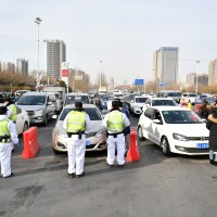 Police officers wearing face masks check drivers' COVID-19 test documentation at an entrance of an expressway