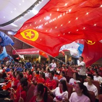 Young Chinese students from local universities wave flags of China and the Communist Youth League of China during a theme event to celebrate the upcoming 100th anniversary of the May Fourth Movement in Hohhot