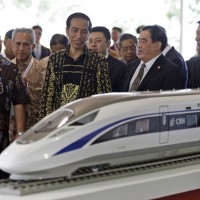 Indonesian President Joko Widodo, center, inspects a model of the high-speed train which will connect the capital city of Jakarta to the country's fourth largest city, Bandung, along with from left to right, West Java Governor Ahmad Heryawan, Director of Indonesia China High Speed Train Hanggoro Budi Wiryawan, President of China Railway Corp.