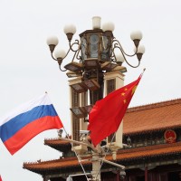 Chinese and Russian national flags flutter on a lamppost in front of the Tian'anmen Rostrum