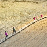 ourists walk on the exposed thousand-hole bridge of the Ming Dynasty in Jiujiang city, East China's Jiangxi province, Sept 3, 2022. As Poyang Lake enters the low and dry season, the thousand-year stone island and the "thousand-hole bridge" on the bed of Poyang Lake are exposed on the dry lake bed.