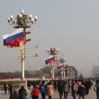 Chinese and Russian national flags flutter on lampposts in front of the Tian'anmen Rostrum