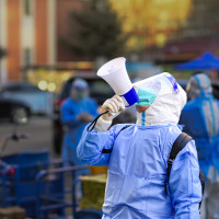  A community worker uses a loudspeaker to organize residents to go downstairs for nucleic acid sampling at a residential community in Hohhot, Inner Mongolia, China, November 15, 2022.