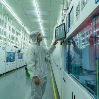 A worker produces photovoltaic cells at an energy Company's cell production workshop in Hefei, East China's Anhui Province