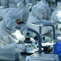 Technical workers produce and examine a mobile phone camera module at a dust-free workshop in Hefei, Anhui Province, China.