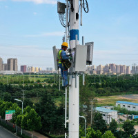 An employee of China Mobile Communications Group checks a 5G base station tower