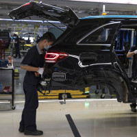 Workers assemble cars at a Beijing Benz Automotive Co. Ltd factory, a German joint venture company for Mercedes-Benz, in Beijing.