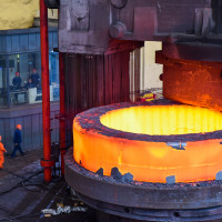 Chinese workers check a seamless forging piece at a forging workshop of CITIC Heavy Industries Company in Luoyang city, central China's Henan province