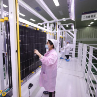 A worker at a photovoltaic company works on a production line in Lianyungang City, Jiangsu Province, China, December 15, 2023.