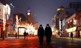 Security guards walking down Wangfujing street in Beijing.