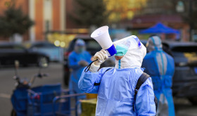  A community worker uses a loudspeaker to organize residents to go downstairs for nucleic acid sampling at a residential community in Hohhot, Inner Mongolia, China, November 15, 2022.