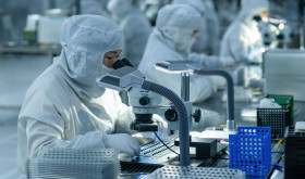 Technical workers produce and examine a mobile phone camera module at a dust-free workshop in Hefei, Anhui Province, China.