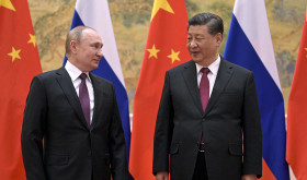 Chinese President Xi Jinping, right, and Russian President Vladimir Putin talk to each other during their meeting in Beijing, China, Friday, Feb. 4, 2022. 