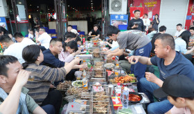 Customers eat skewers at Muyang Village Grill in Zibo, East China's Shandong province